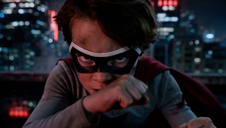 Frame from the cut: close-up of the masked boy, fists up, in the neon night